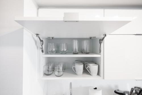 a kitchen shelf with glasses and cups on it at Modern Lakefront Esc Stylish 2BR Condo with Patio in Toronto