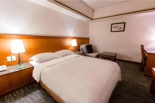 a large white bed in a hotel room at Hub Hotel Ximen-inn Kunming in Taipei