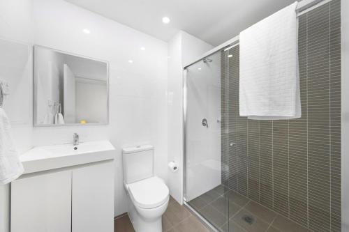 シドニーにある2BR APT Ideal for Families or Business Staysのトイレとシャワー付きの白いバスルーム