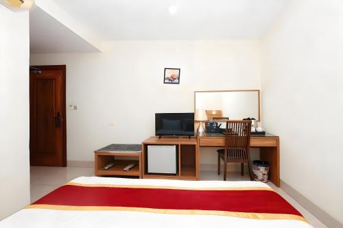 Una televisión o centro de entretenimiento en 中青秋果酒店金边王宫店 True Go Hotel
