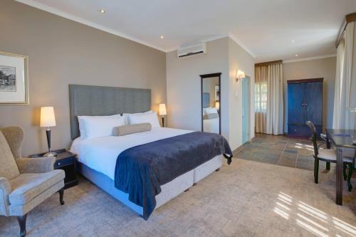 a bedroom with a bed and a chair and a desk at Protea Hotel by Marriott Mossel Bay in Mossel Bay