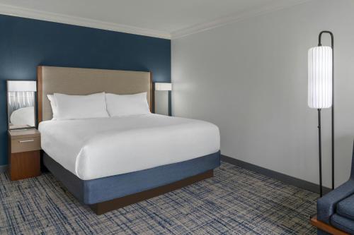 a bedroom with a large white bed and a lamp at Courtyard Palo Alto Los Altos in Palo Alto