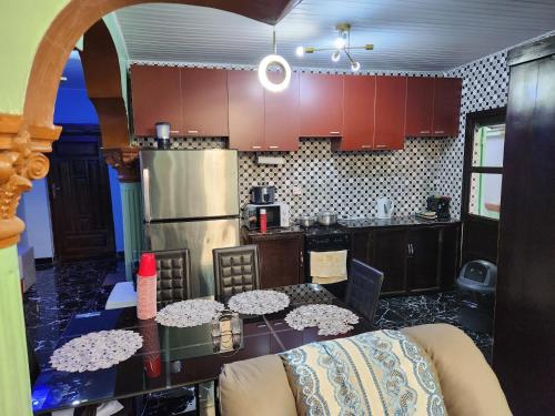 a kitchen with a table with chairs and a refrigerator at Cozy Flat 5 Minutes To Beach in Freetown