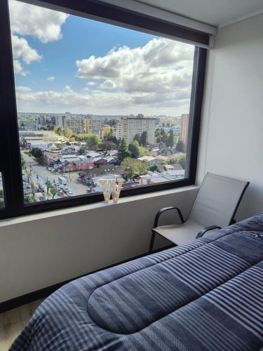 a bedroom with a bed and a large window at Departamento 2D 2B 4-5 Personas in Temuco