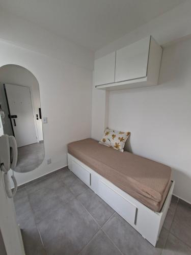 a small bedroom with a bed and a mirror at Studio Teresa - 200m UFSJ e Igreja São Francisco in São João del Rei