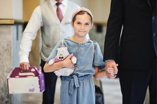 a little girl holding a teddy bear and a man at Hotel Bristol, A Luxury Collection Hotel, Warsaw in Warsaw