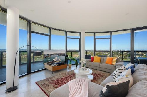 a living room with a lot of glass windows at Spacious Two Level 4BR at Sydney Olympic Park with Best View in Sydney