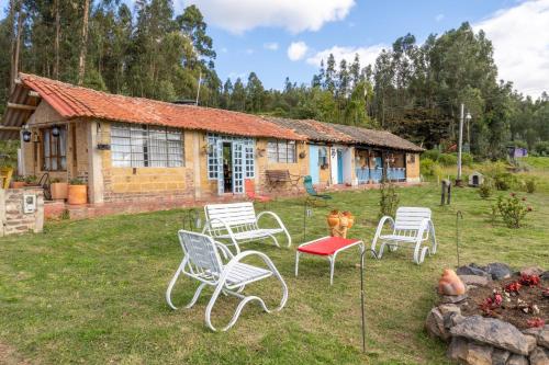 a group of chairs in front of a house at Cabañas Santa Teresa de las Flores in Sogamoso