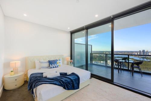 シドニーにあるSpacious Two Level 4BR at Sydney Olympic Park with Best Viewのベッドルーム1室(ベッド1台、大きなガラス窓付)