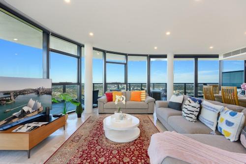 a living room filled with furniture and glass windows at Spacious Two Level 4BR at Sydney Olympic Park with Best View in Sydney