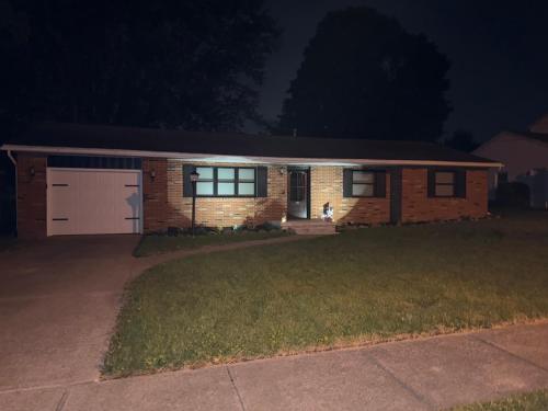 a small brick house with a garage at night at Blessed Beyond Measure-King Master with Ensuite in Norwalk