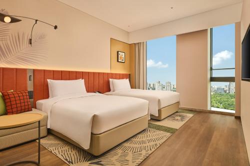 a hotel room with two beds and a window at Hilton Garden Inn Chongqing Yubei Central Park in Chongqing