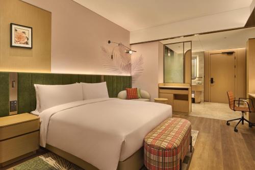 a hotel room with a bed and a bathroom at Hilton Garden Inn Chongqing Yubei Central Park in Chongqing