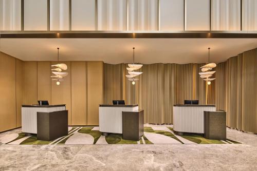 a lobby with four tables and lights on the wall at Hilton Garden Inn Chongqing Yubei Central Park in Chongqing