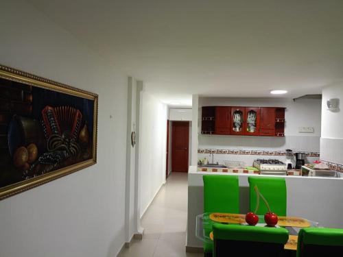 una cucina con tavolo e alcune sedie verdi di Valdy hause 202 a Gaira