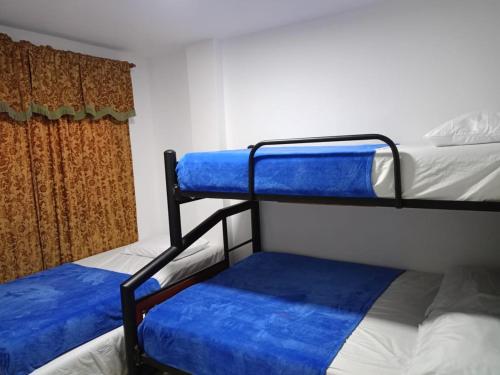 una camera con 2 letti a castello con lenzuola blu di Valdy hause 202 a Gaira