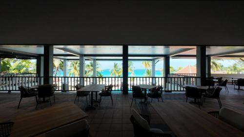 a restaurant with tables and chairs and a view of the ocean at Peridot By The Sea Redang in Redang Island