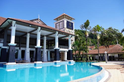 a building with a clock tower next to a swimming pool at Peridot By The Sea Redang in Redang Island