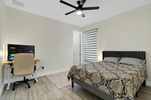 a bedroom with a bed and a desk with a computer at Sunny Stay Orlando Queen Room 3 with Shared Bath in Orlando