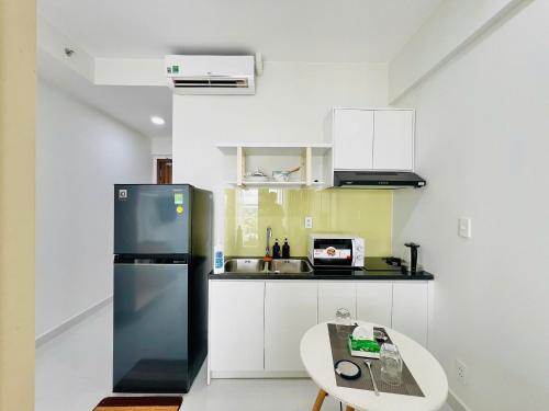 a kitchen with a refrigerator and a table at New Lavida in Dĩ An