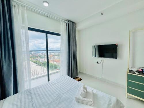 a bedroom with a bed and a large window at New Lavida in Dĩ An