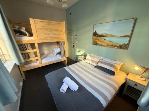 a bedroom with a large bed and a bunk bed at UpTown Backpackers in Dunedin