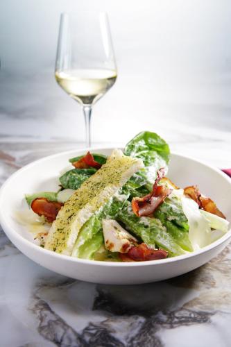 a plate of salad with a glass of white wine at TRIMULIA Hotel in Sihanoukville
