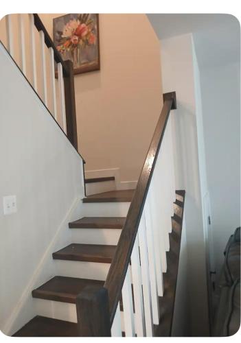 a staircase with white walls and a picture on the wall at Red sound retreat in Laurel
