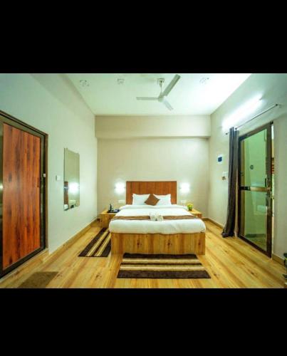 a bedroom with a large bed with a wooden headboard at Cayana Palms in Sāhān