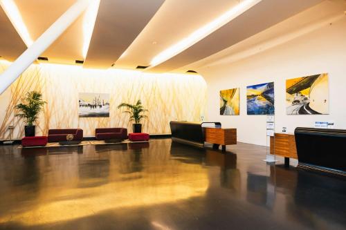 a living room with couches and paintings on the walls at Sheraton Milan Malpensa Airport Hotel & Conference Centre in Ferno