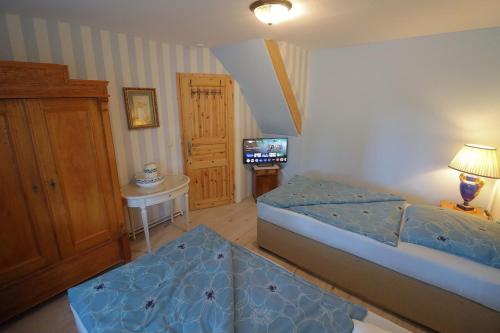 a bedroom with a bed and a television in it at Berlinurlaub im Grünen, Pool-Whirlpool beheizt, Sauna, Spielplatz, Grill, 3 Doppelzimmer in Blankenfelde