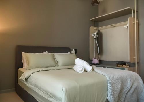 a bed with two towels sitting on top of it at Cozy studio with Komtar view at 22 Macalisterz in George Town