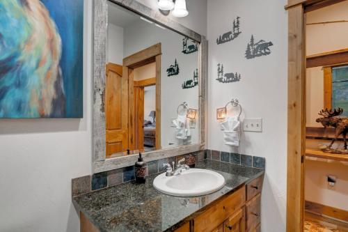 a bathroom with a sink and a mirror at Cozy Condo | Hot Tub Views | Steps to Ski Shuttle in Big Sky Mountain Village