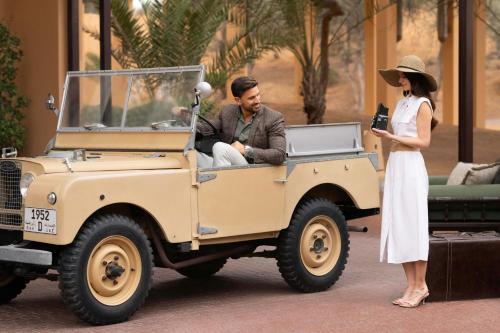 a man and a woman standing next to a jeep at The Ritz-Carlton Ras Al Khaimah, Al Wadi Desert in Ras al Khaimah