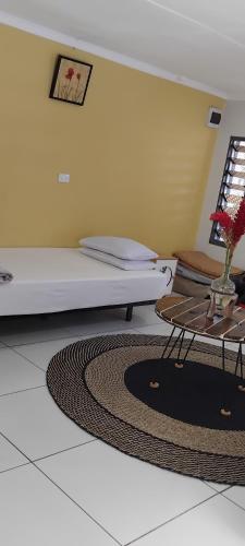a room with a bed and a table and a rug at Aggies homestay in Nadi in Nadi International Airport