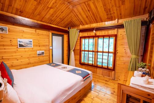 a bedroom with a bed in a wooden room at Eco Farmer House - Sapa Retreat in Sa Pa