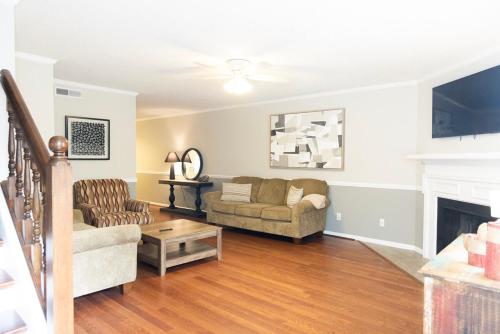 a living room with a couch and a fireplace at 2 Bedroom Townhouse Retreat 10 min to UA Stadium in Tuscaloosa