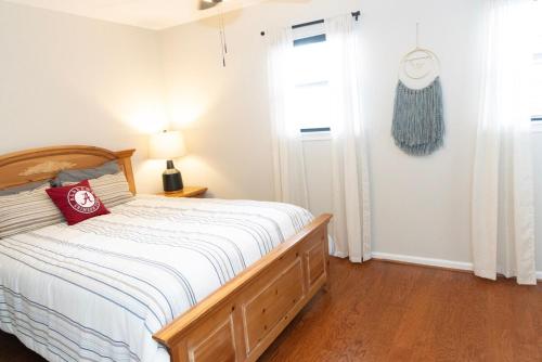 a bedroom with a bed with a red pillow on it at 2 Bedroom Townhouse Retreat 10 min to UA Stadium in Tuscaloosa