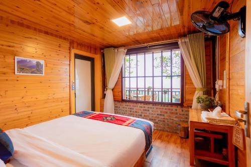 a bedroom with a bed and a large window at Eco Farmer House - Sapa Retreat in Sa Pa