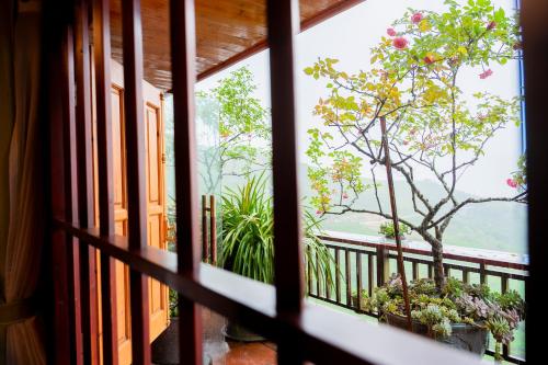a window view of a tree from a balcony at Eco Farmer House - Sapa Retreat in Sa Pa