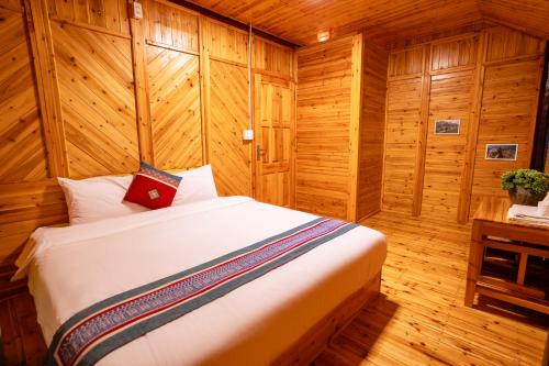 a bedroom with a bed in a wooden room at Eco Farmer House - Sapa Retreat in Sa Pa