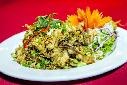 a white plate of food on a red table at Phi Phi Banyan Villa in Phi Phi Don