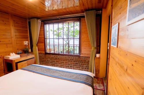 a bedroom with a bed in a room with a window at Eco Farmer House - Sapa Retreat in Sa Pa