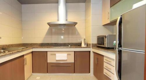 a kitchen with a sink and a stove at Plaza Sutera Biru Hotel in Kuala Belait