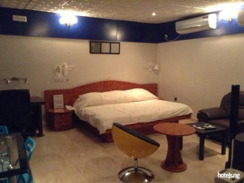 a bedroom with a bed and a chair and a couch at Sunview Hotel - akure in Akure