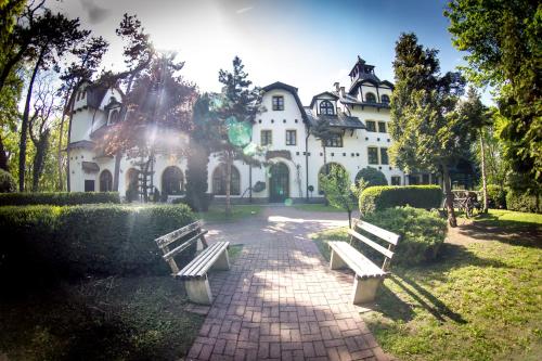 two park benches in front of a building at Hotel Maria in Strzelin