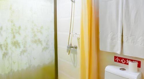 a bathroom with a shower and a toilet and a sink at My Pleasant Hotel in Shenzhen