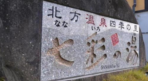 a sign on a rock with asian writing on it at Nanaironoyu Hotel in Takeo