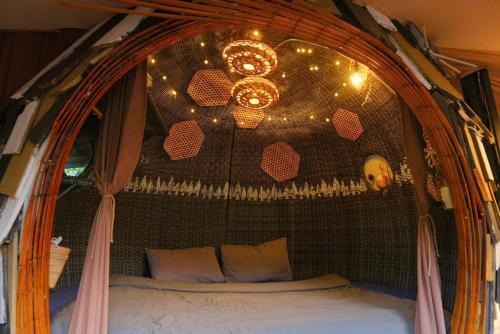 a bedroom with a canopy bed with a chandelier at Cú Trên Cây Homestay in Xuan An