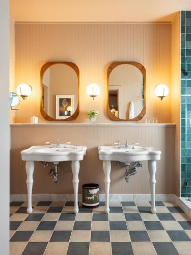 two sinks in a bathroom with two mirrors at Le Petit Pali St Helena in St. Helena